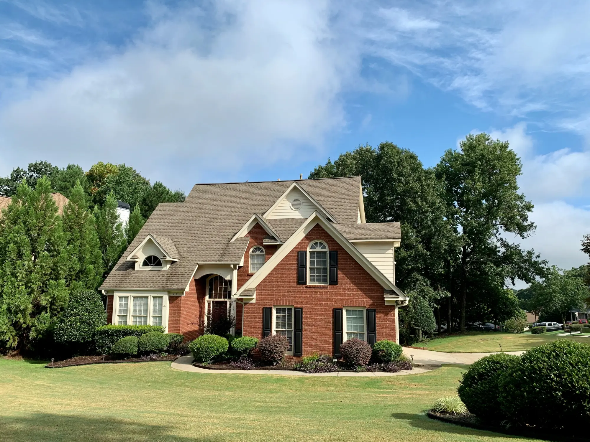 red brick house surrounded by trees